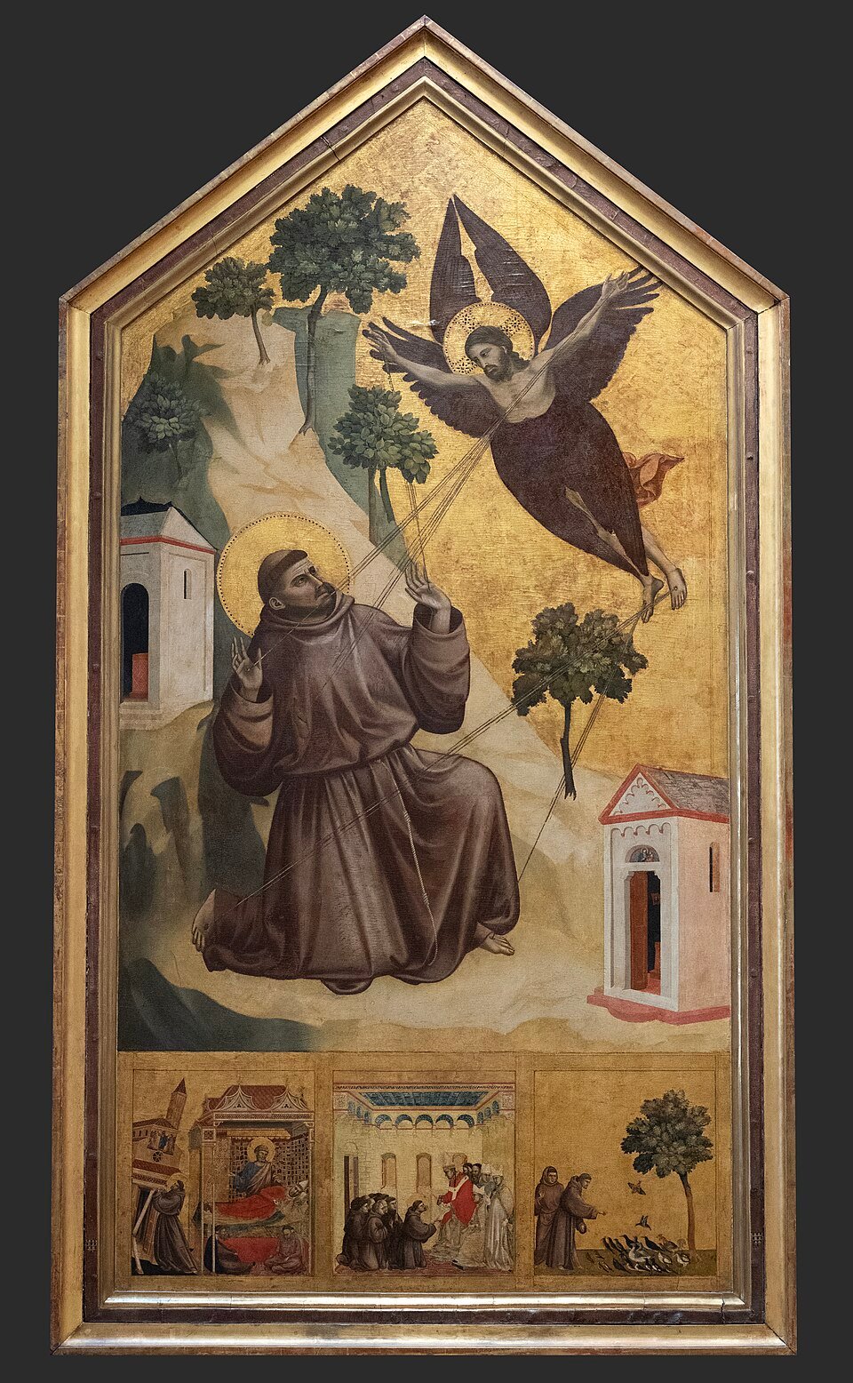 A gold-ground altarpiece showing a kneeling friar in a brown habit receiving rays from a winged figure in the sky, with small chapels and trees on a rocky hillside and three narrative panels beneath.