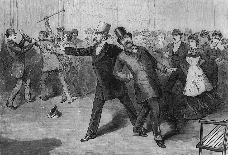 An engraving of a bearded man in a top hat collapsing into the arms of a companion on a station platform while bystanders seize a man behind them.