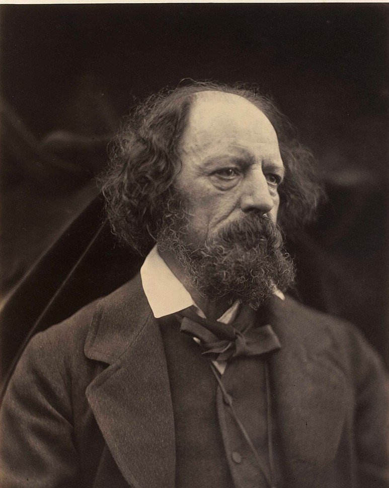 A soft-focus sepia portrait of an elderly man with long grey hair and a full beard, wearing a dark coat and loosely tied cravat.