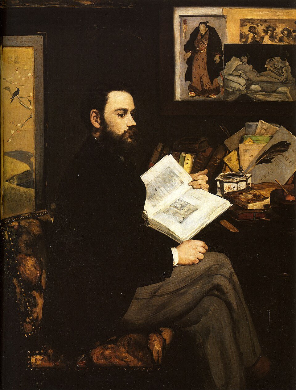 A painting of a bearded man in a dark suit seated in profile holding an open illustrated book, with prints and papers pinned behind him.